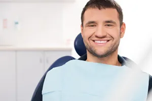 Photo of a smiling man in a patient chair for oral surgery
